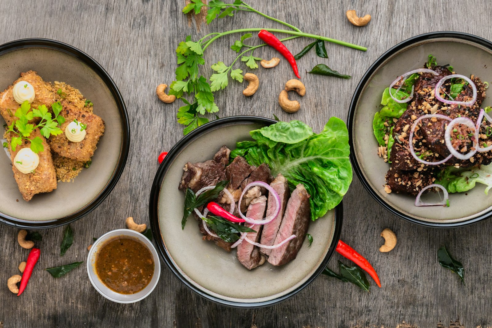 A warm spread of freshly prepared, chef-plated food on a wooden table